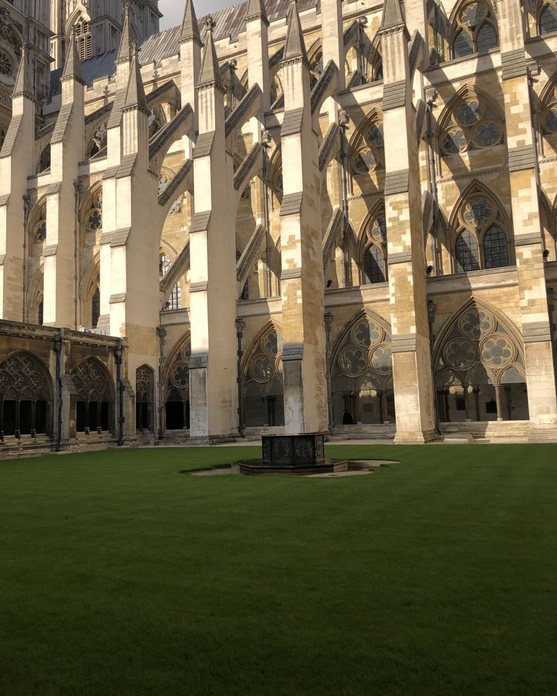 Gothic stonework above a cloister lawn at Westminster
